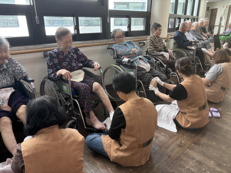 자원봉사자분들이 어르신들에게 발마사지 해주시는 모습