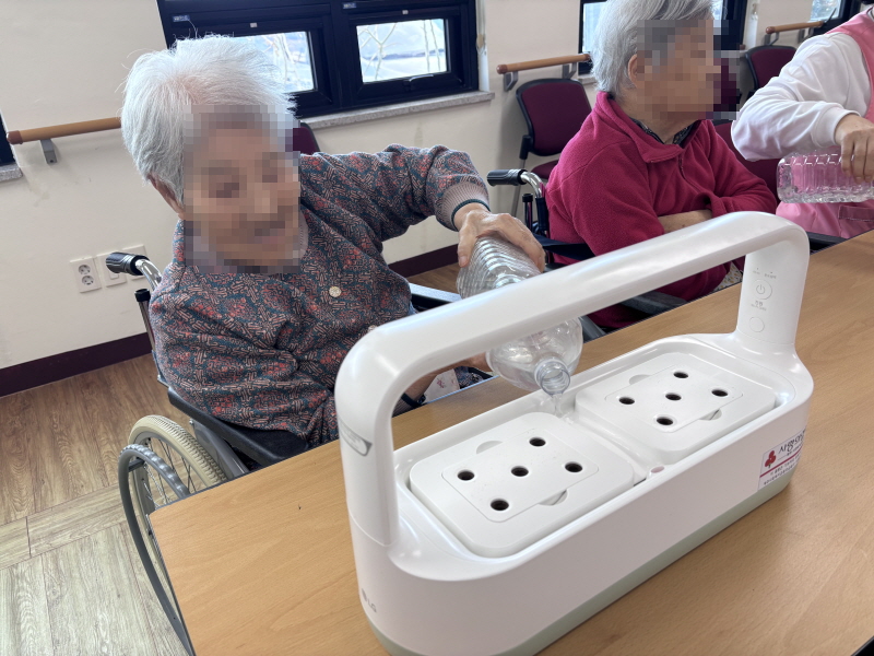 어르신들이 식물재배기에 물 채우는 모습