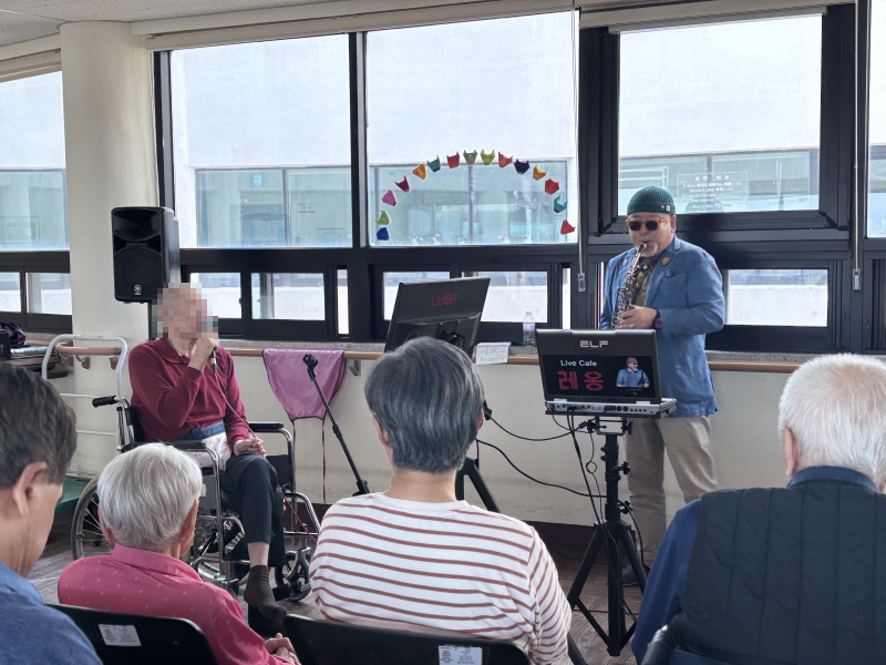 색소폰 연주에 맞춰 노래하는 어르신 모습