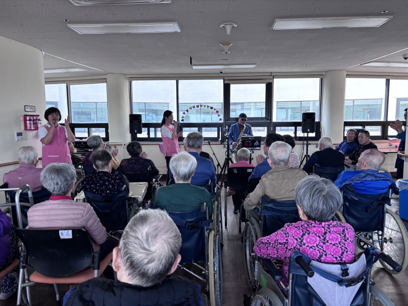 색소폰 공연 관람하는 어르신들 모습