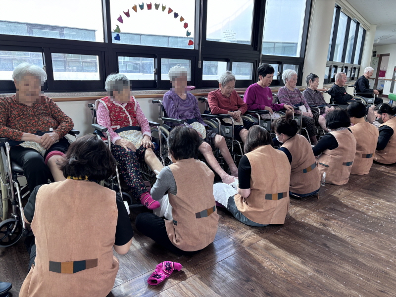 자원봉사자분들이 어르신들께 아로마 발마사지 하는 모습