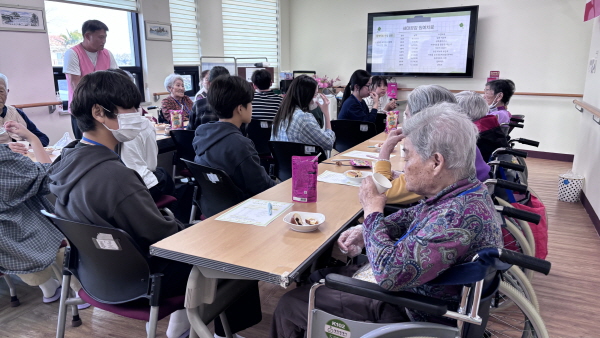어르신들과 청소년들이 만나 얘기하며 간식 나눠먹는 모습