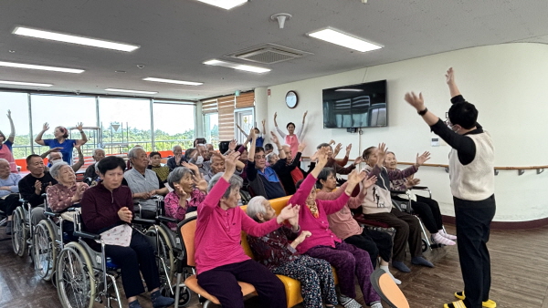 어르신들이 팔을 위로 뻗어 스트레칭하는 모습