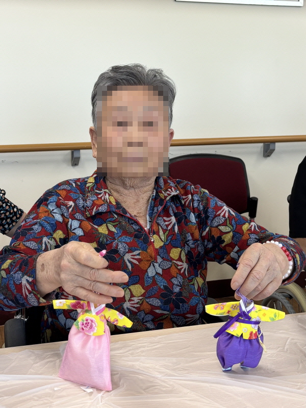 양손에 한복 향주머니를 들고 계신 어르신