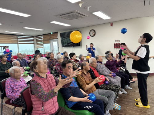 강사와 함께 어르신들이 성게볼로 체조하는 모습  