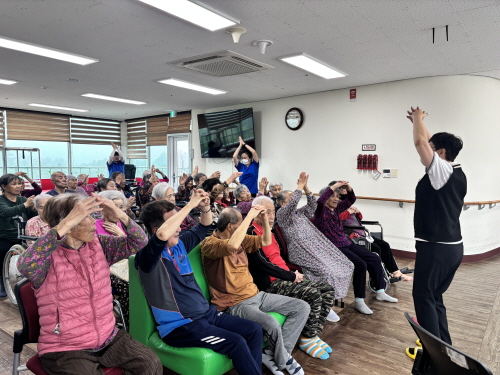 강사와 함께 어르신들이 손체조하는 모습  
