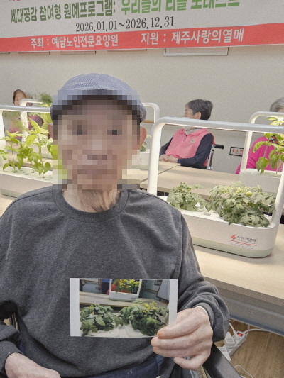 남자 어르신이 식물 사진을 들고 있는 모습