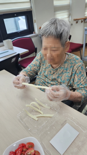 여자 어르신이 치즈를 뜯고 있다