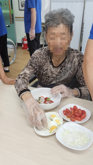 여자어르신이 샐러드를 만들고 있다