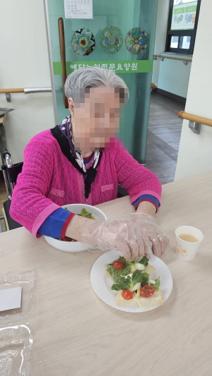 여자어르신이 샐러드를 만들고 있다