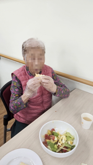 여자어르신이 샌드위치를 먹고 있다