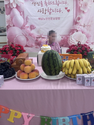 여자 어르신이 생신상앞에 앉아 계시다