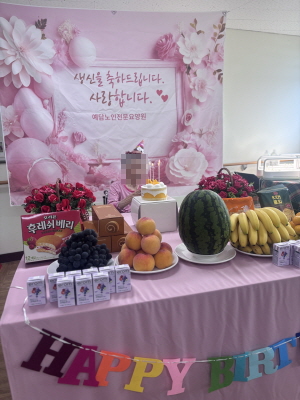 여자 어르신이 생신상앞에 앉아 계시다
