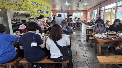 20여명의 사람들이 식사를 하고 있다