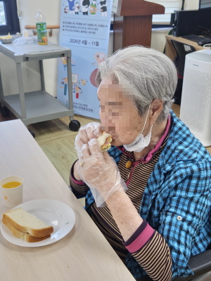 여자 어르신이 샌드위치 드시는 모습